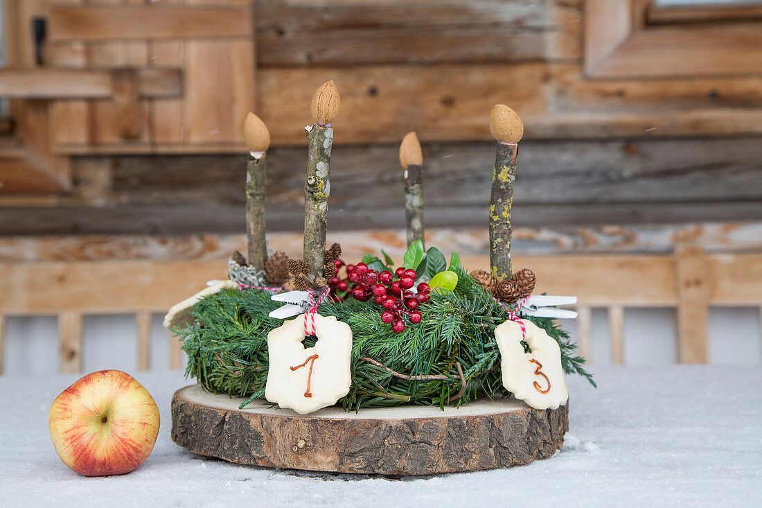 Adventskranz mit nummerierten Plätzchen und Kerzen aus Holz