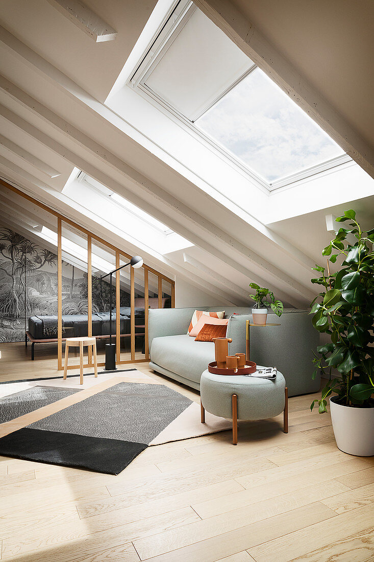 A bright living room with an upholstered sofa in an attic room
