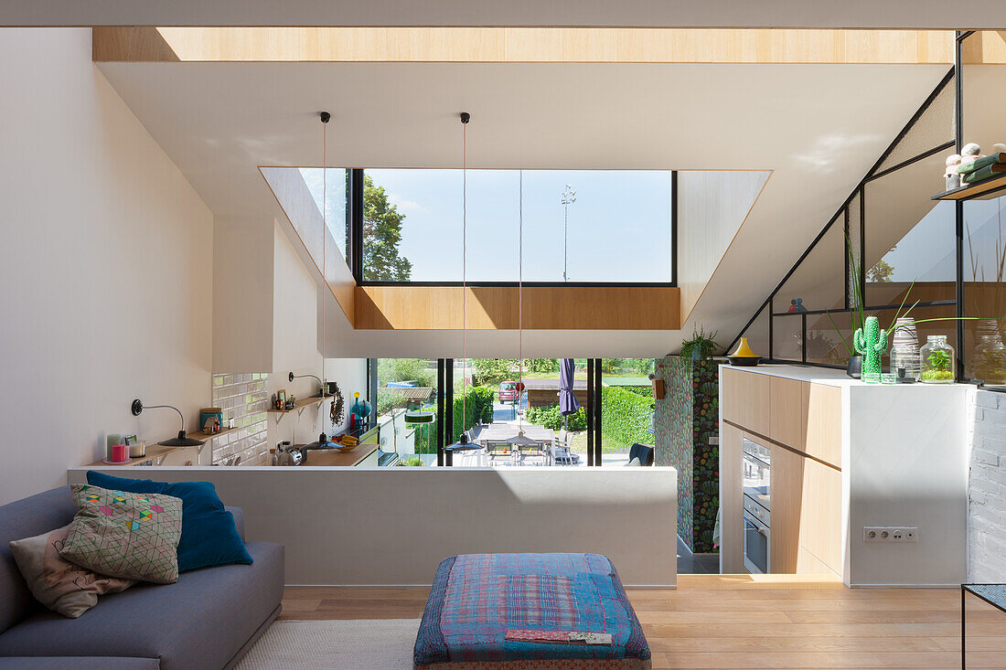 Loft-style living room with view of kitchen and large windows