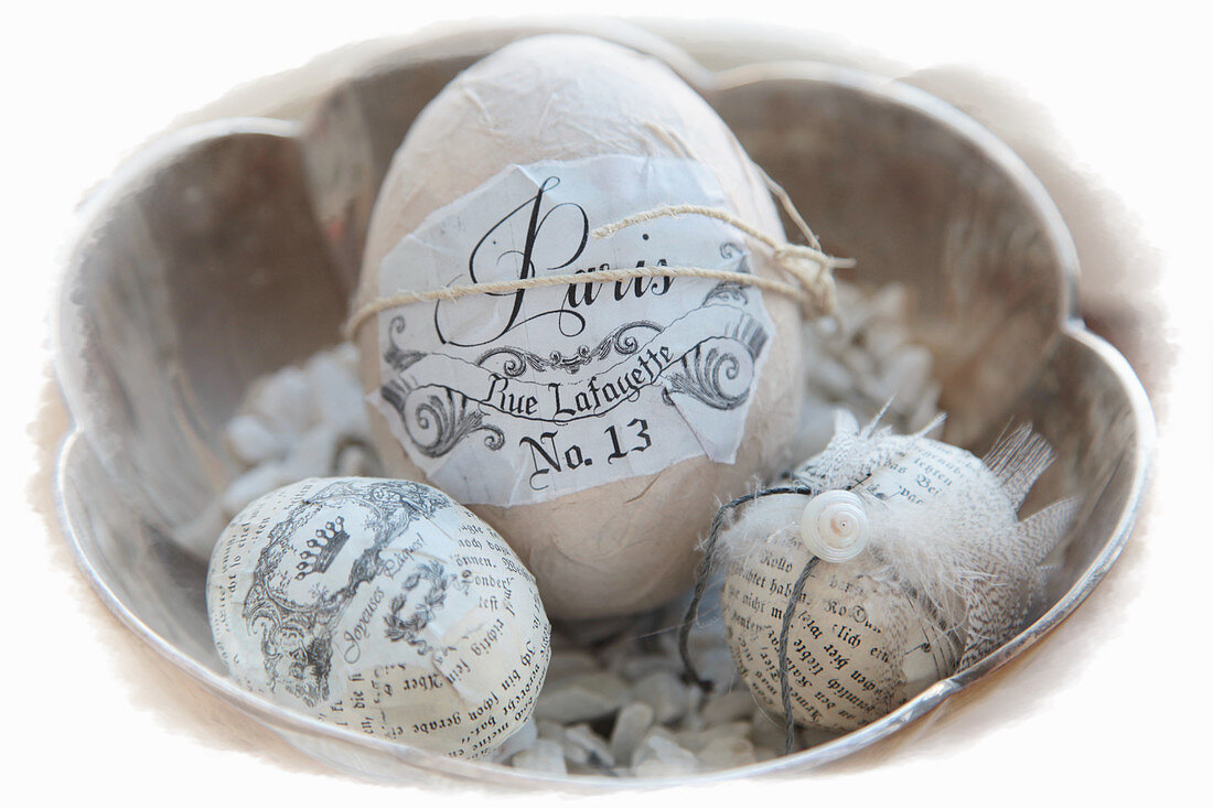 Easter eggs decorated with magazine clippings in silver bowl