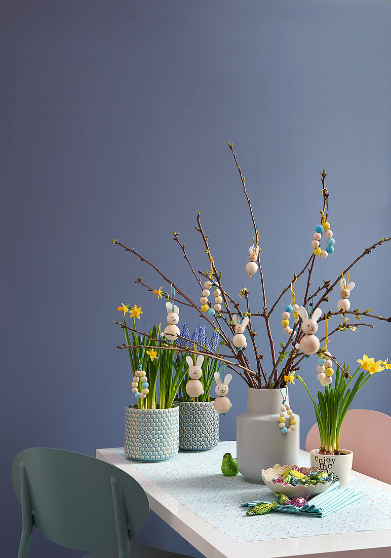 Handmade Easter decorations made from wooden bead on branches in vases