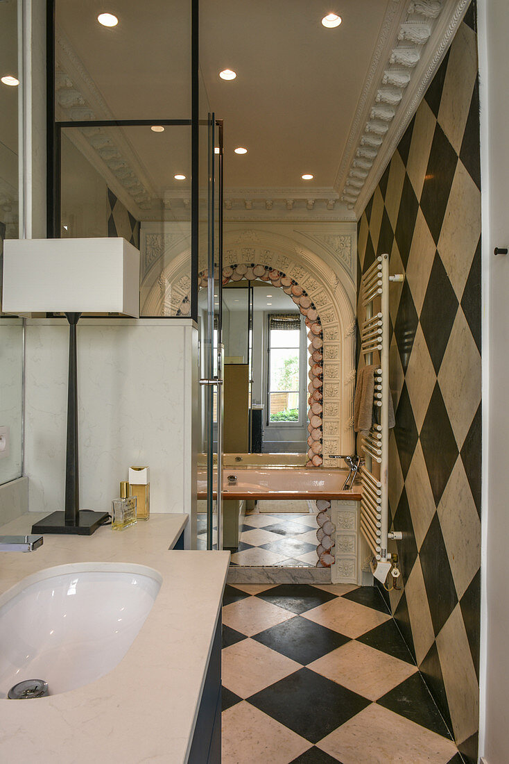 Chequered pattern on floor and walls in bathroom with stucco elements