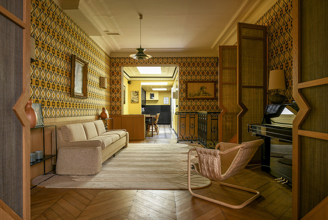 Patterned wallpaper in living room with double doors and view into kitchen