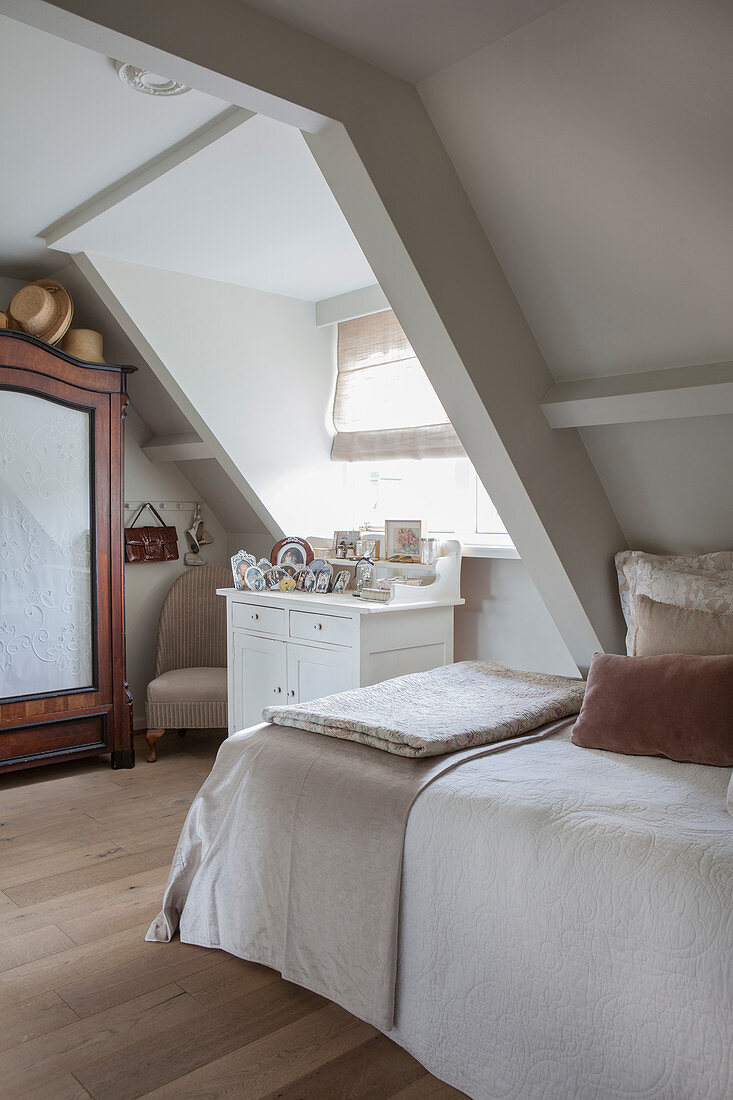 A classic attic bedroom with a gable window