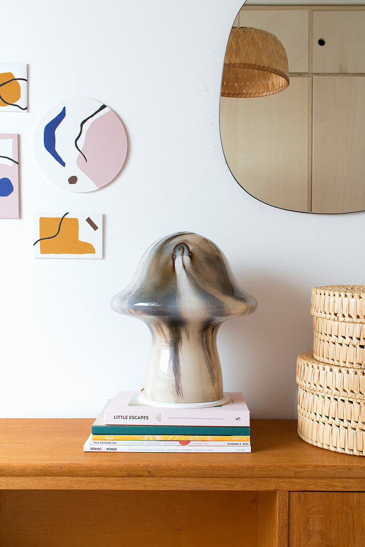 Mushroom-shaped, marbled table lamp on stacked books