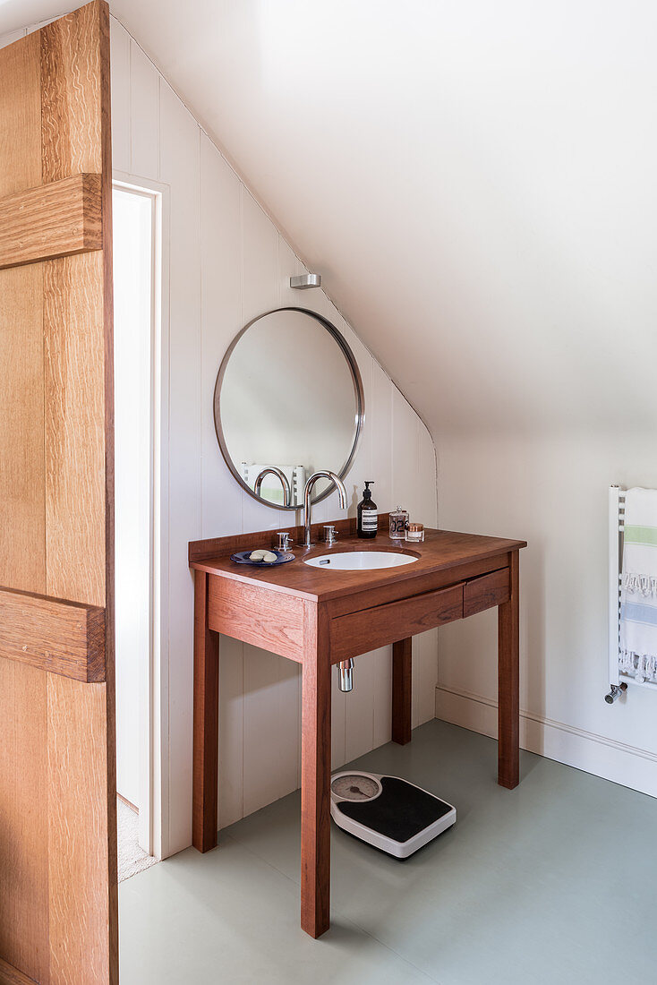 Teak washstand and round mirror in bathroom