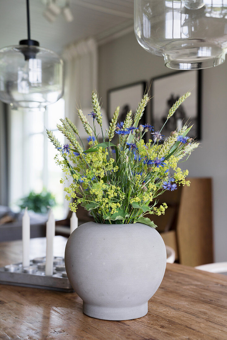 A bouquet of meadow flowers in an earthenware vase