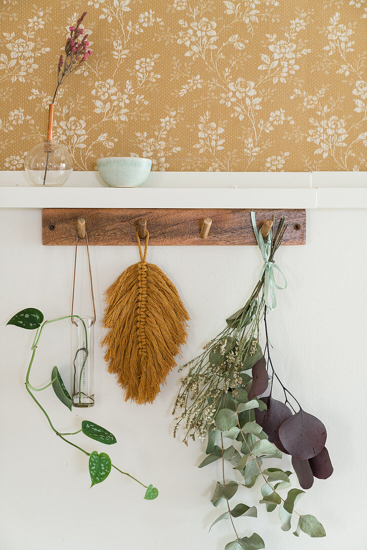 Leaves hanging from wooden rack on wall