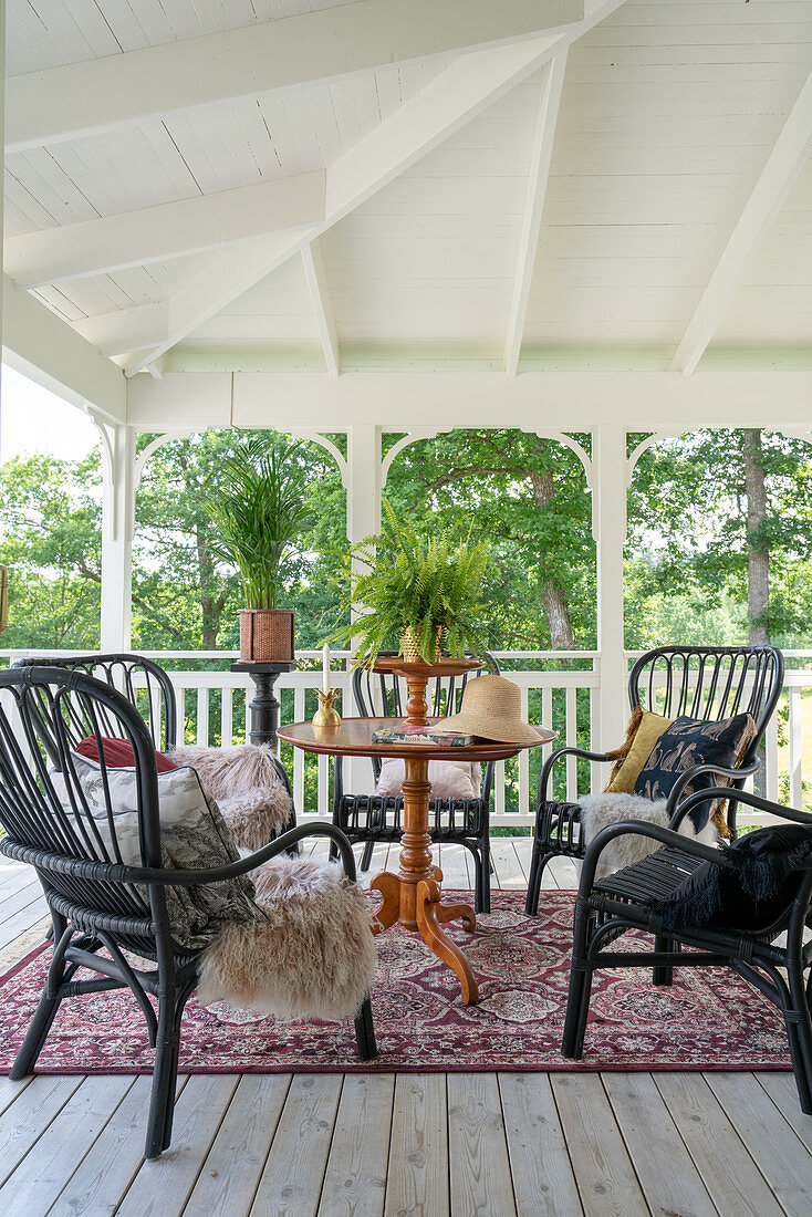 An antique table with comfortable chairs on a covered terrace