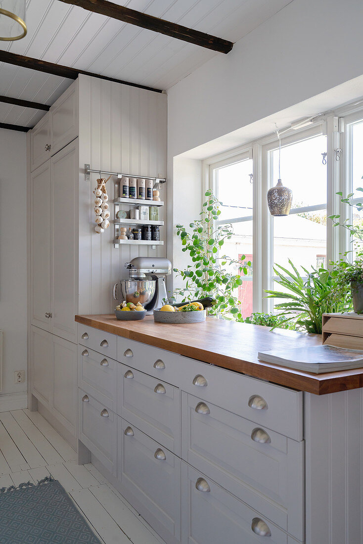 A white Scandinavian-style kitchen with a wooden worktop