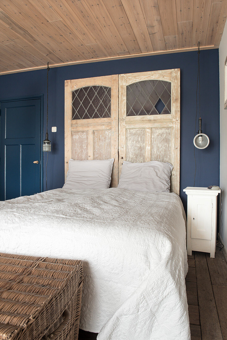 Alte Türen als Bettkopfteil im Schlafzimmer mit blauer Wand