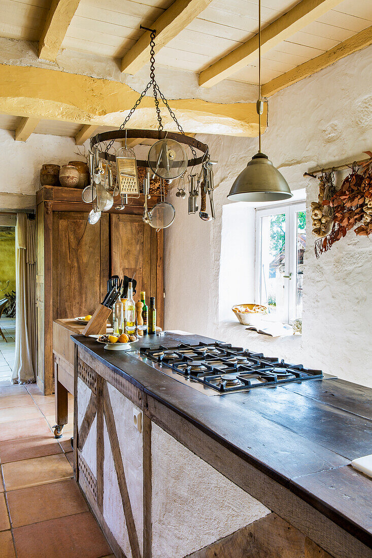 Lange Theke mit Gasherd in Landhausküche mit Holzbalkendecke
