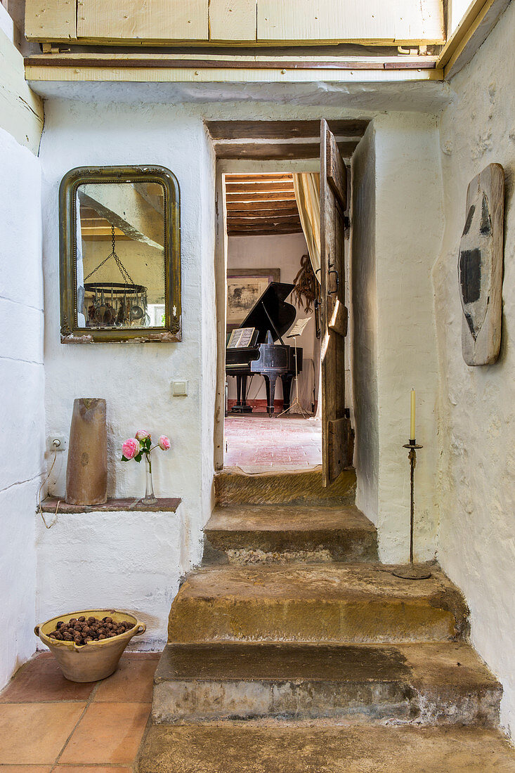 Rustikale Treppenstufen führen zum Zimmer mit Klavier