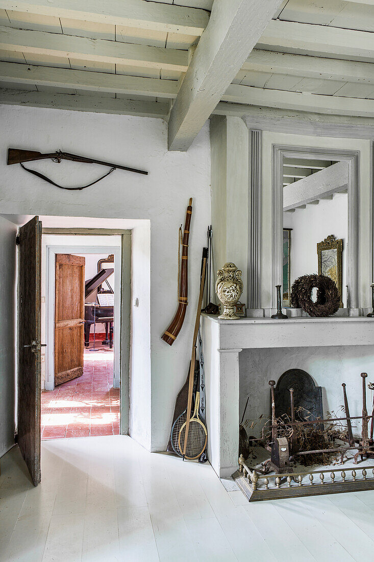 Fireplace with mirror and hunting rifle in rustic room