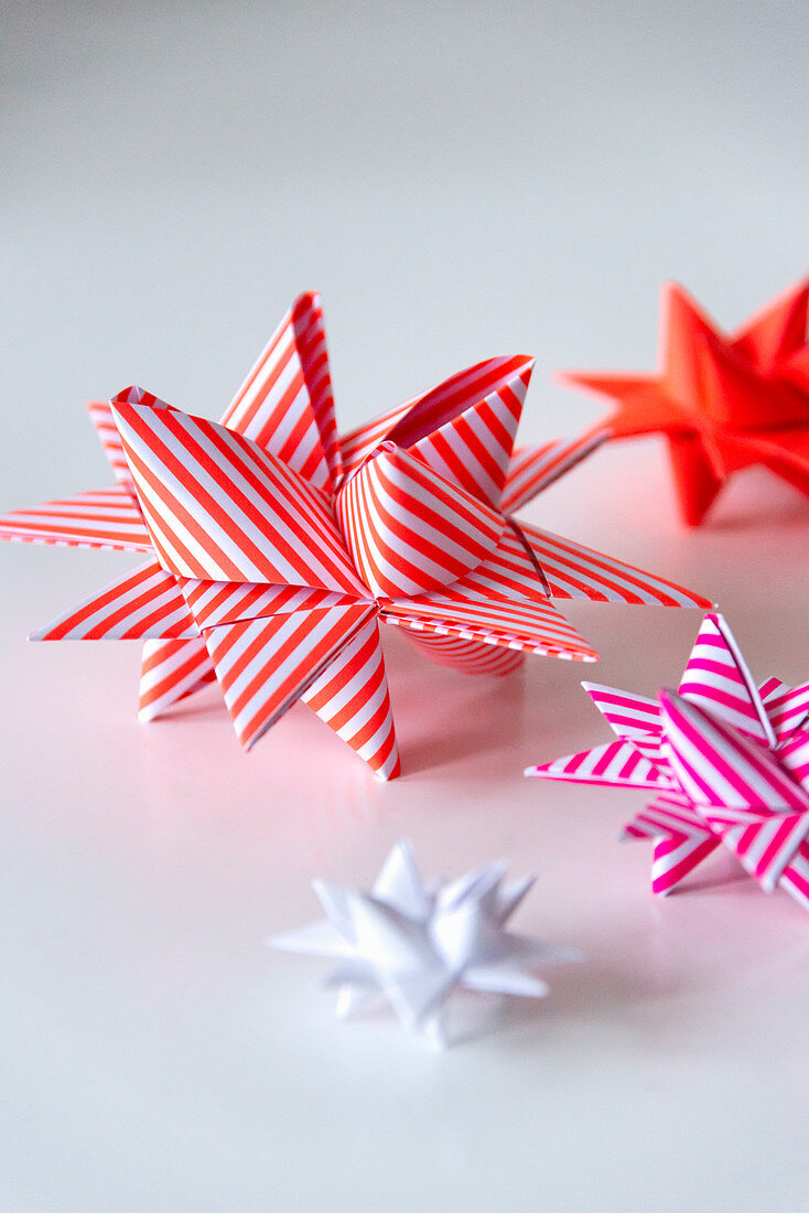 Origami 3D stars made from striped paper in shades of red