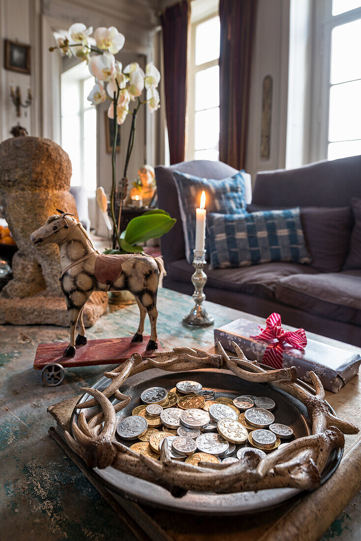 Chocolate money and vintage toys with burning candle on coffee table