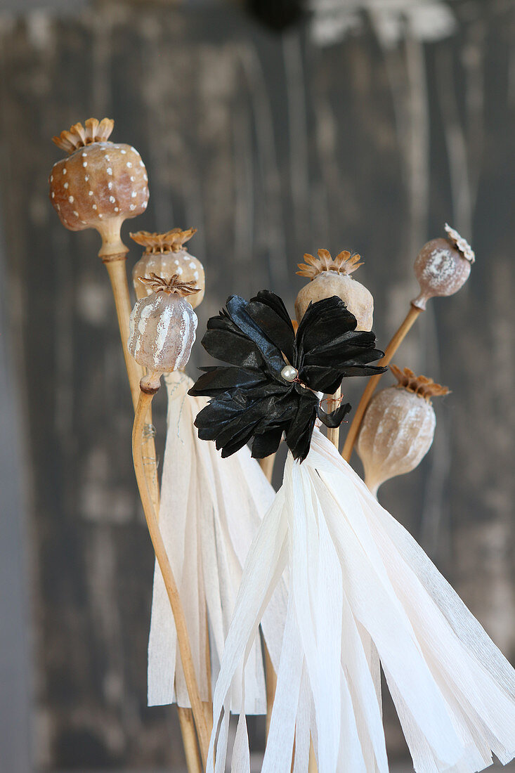 Poppy seed heads painted with patterns and paper flower