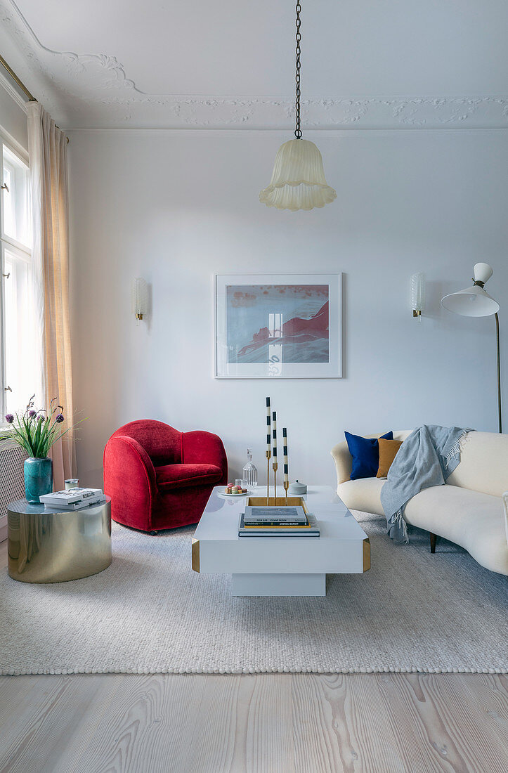 Roter Sessel, goldener Beistelltisch und beiges Sofa im Wohnzimmer