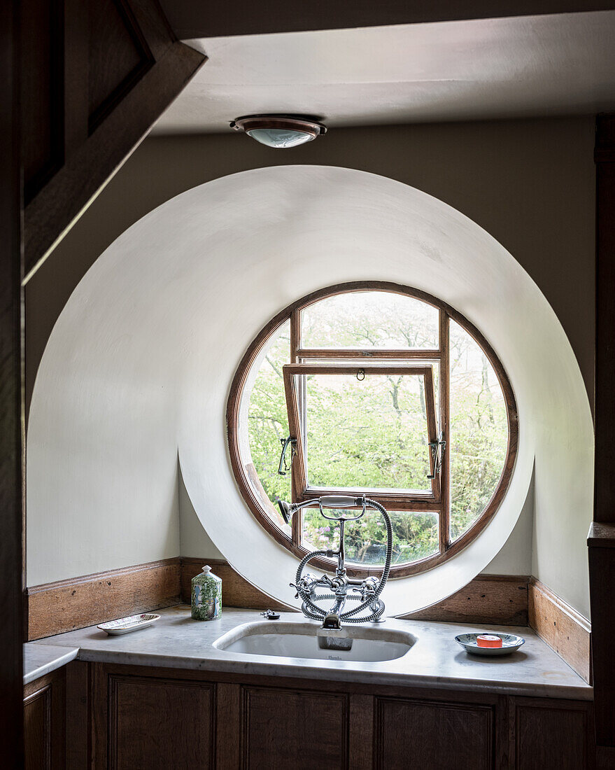 Eingebautes Waschbecken in der Fensternische mit rundem Fenster