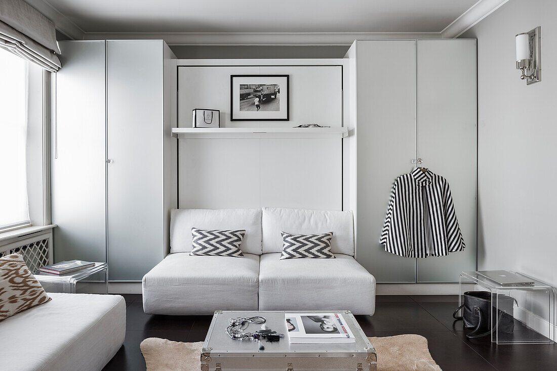Zweisitzer-Sofa flankiert von Kleiderschränken im monochromen Wohnzimmer