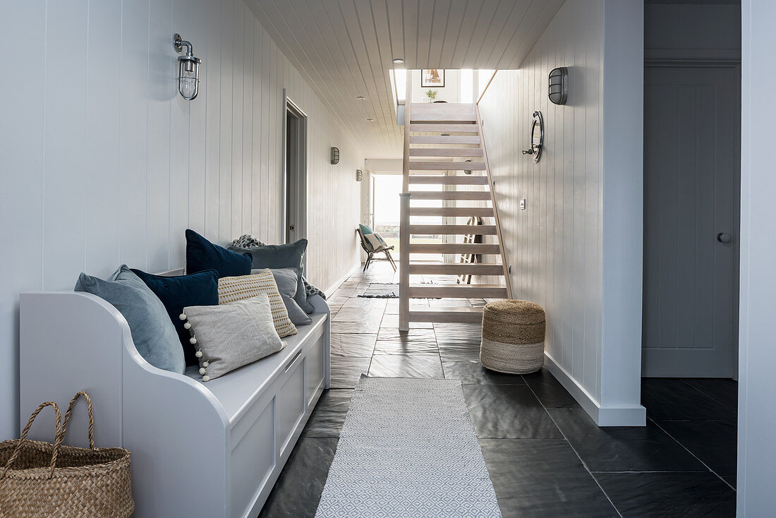Spacious hallway with tongue-and-groove panelling and practical slate flooring
