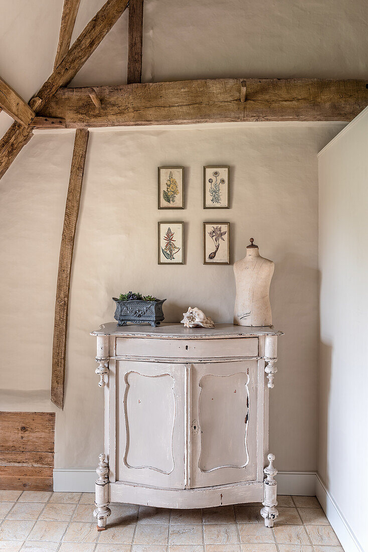 Mannequin on sideboard with botanical prints in restored 16th century farmhouse