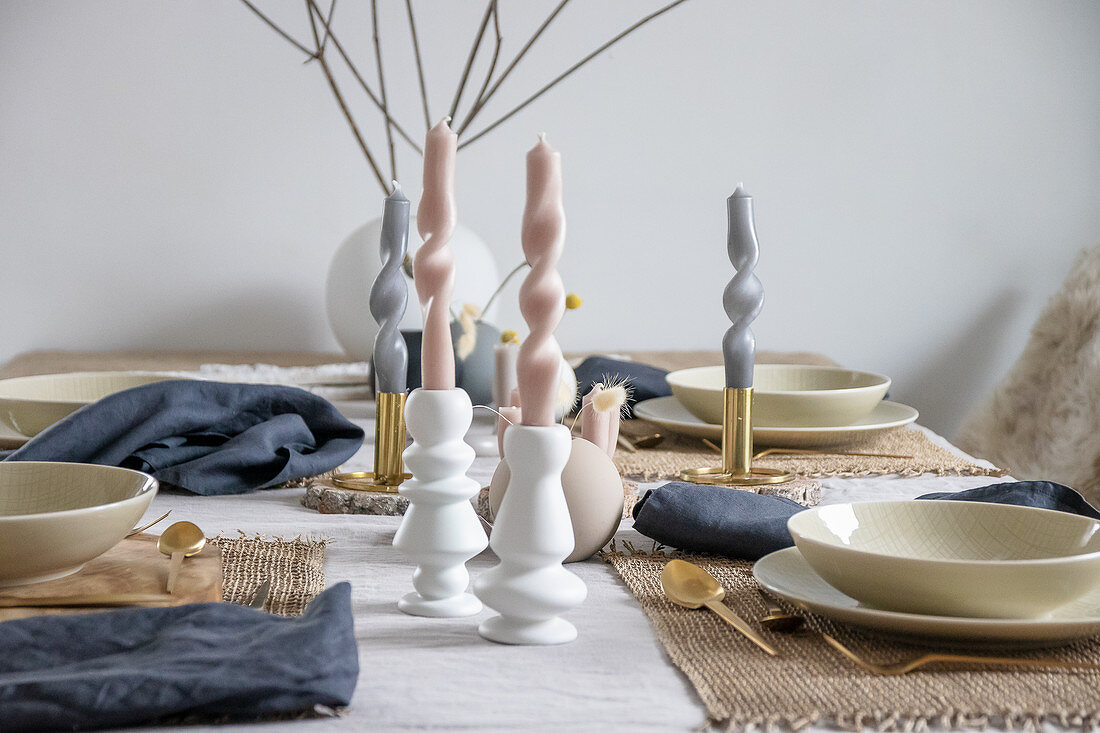 Kunstvoll gedrehte, pastellfarbene Kerzen als Tischdekoration
