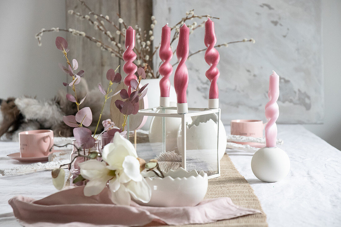 Artistically twisted candles on table set for Easter meal