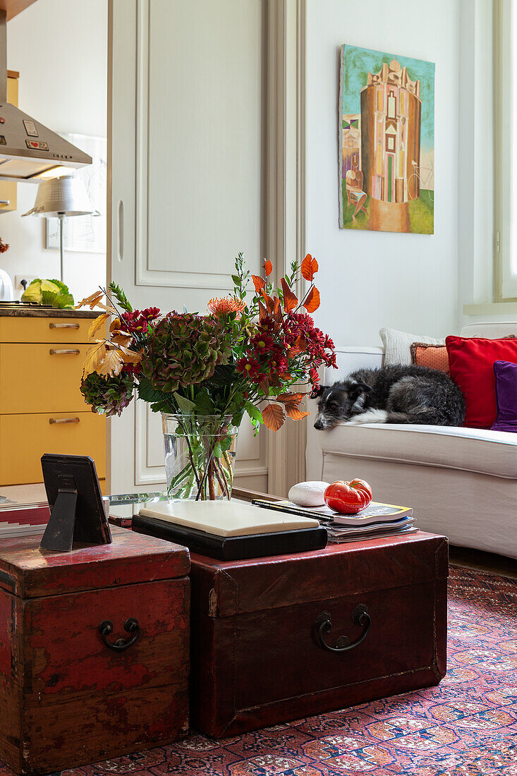 Anitke Truhen mit Blumenstrauß als Couchtisch im Wohnzimmer