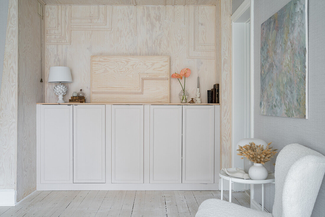 Storage space with white-stained plywood in wall niche