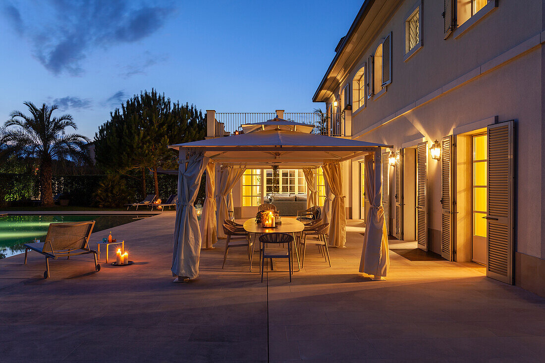 Beleuchtete Villa mit Pavillon auf der Terrasse