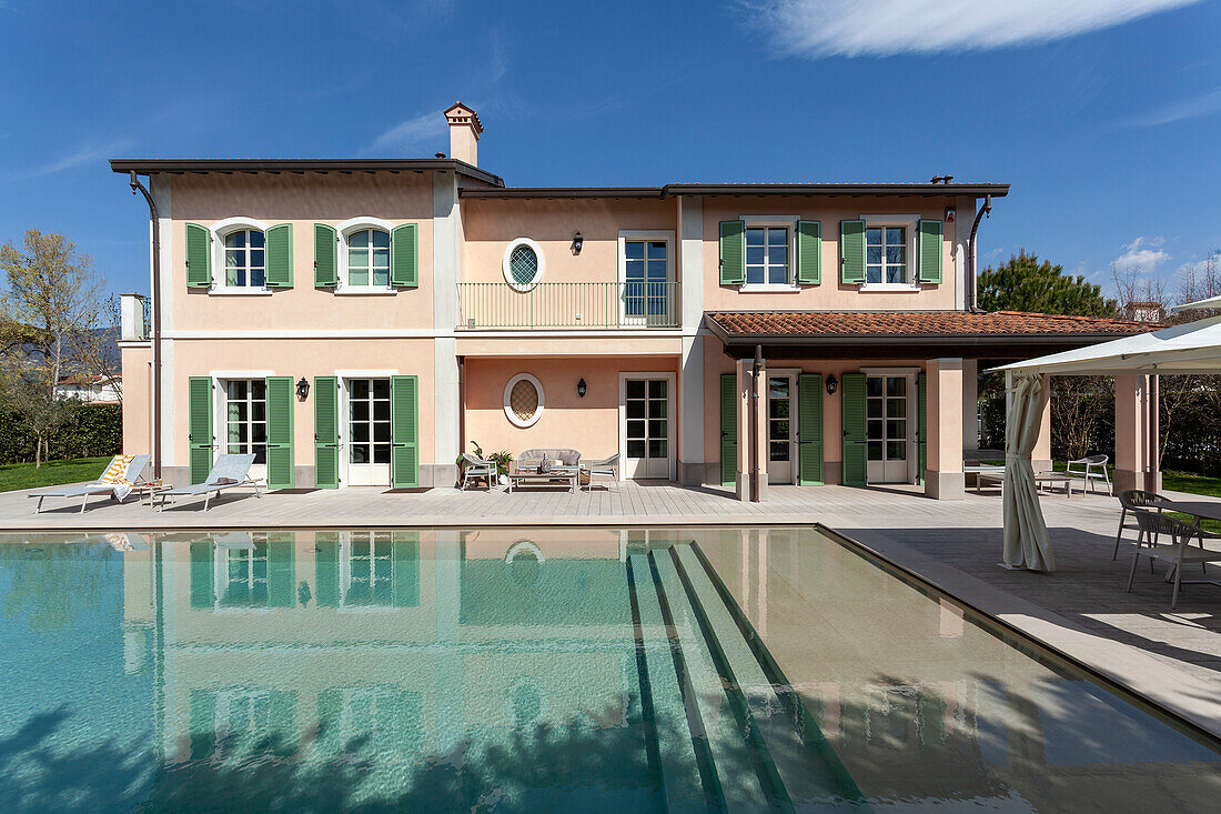 Pool und Villa mit grünen Fensterläden