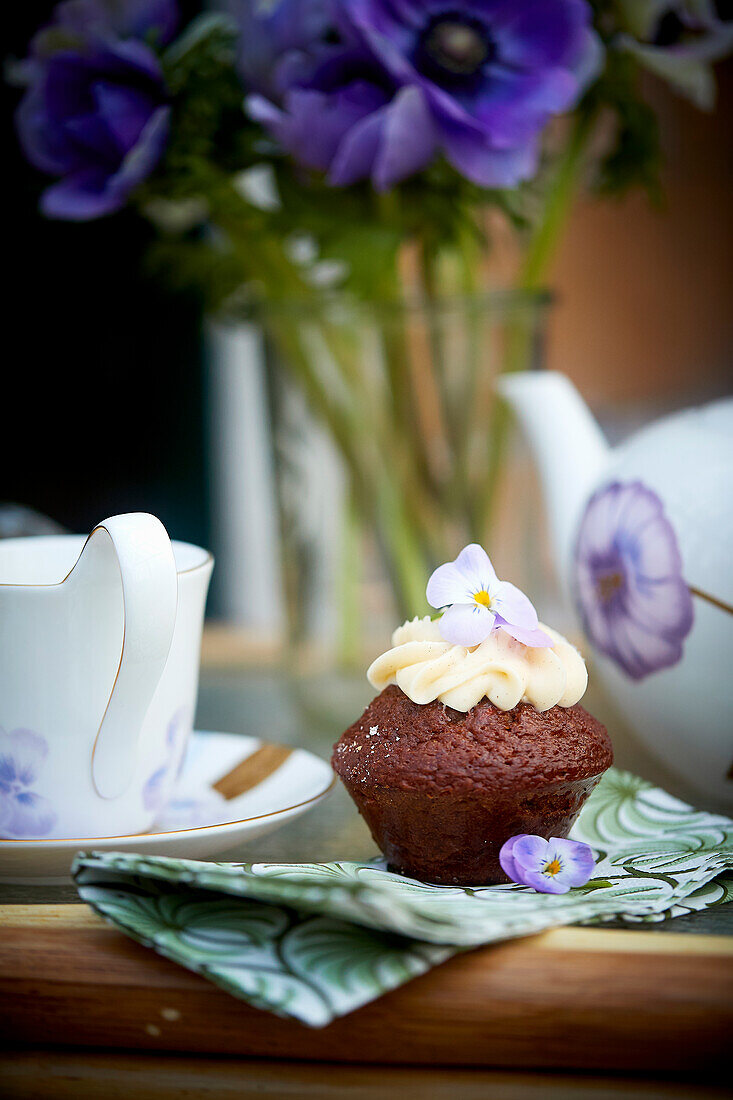 Chocolate muffin with cream and violets