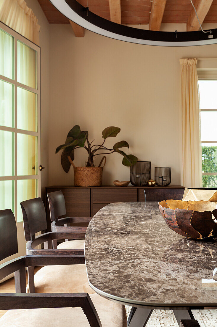 A dining table with a marble top and upholstered chairs