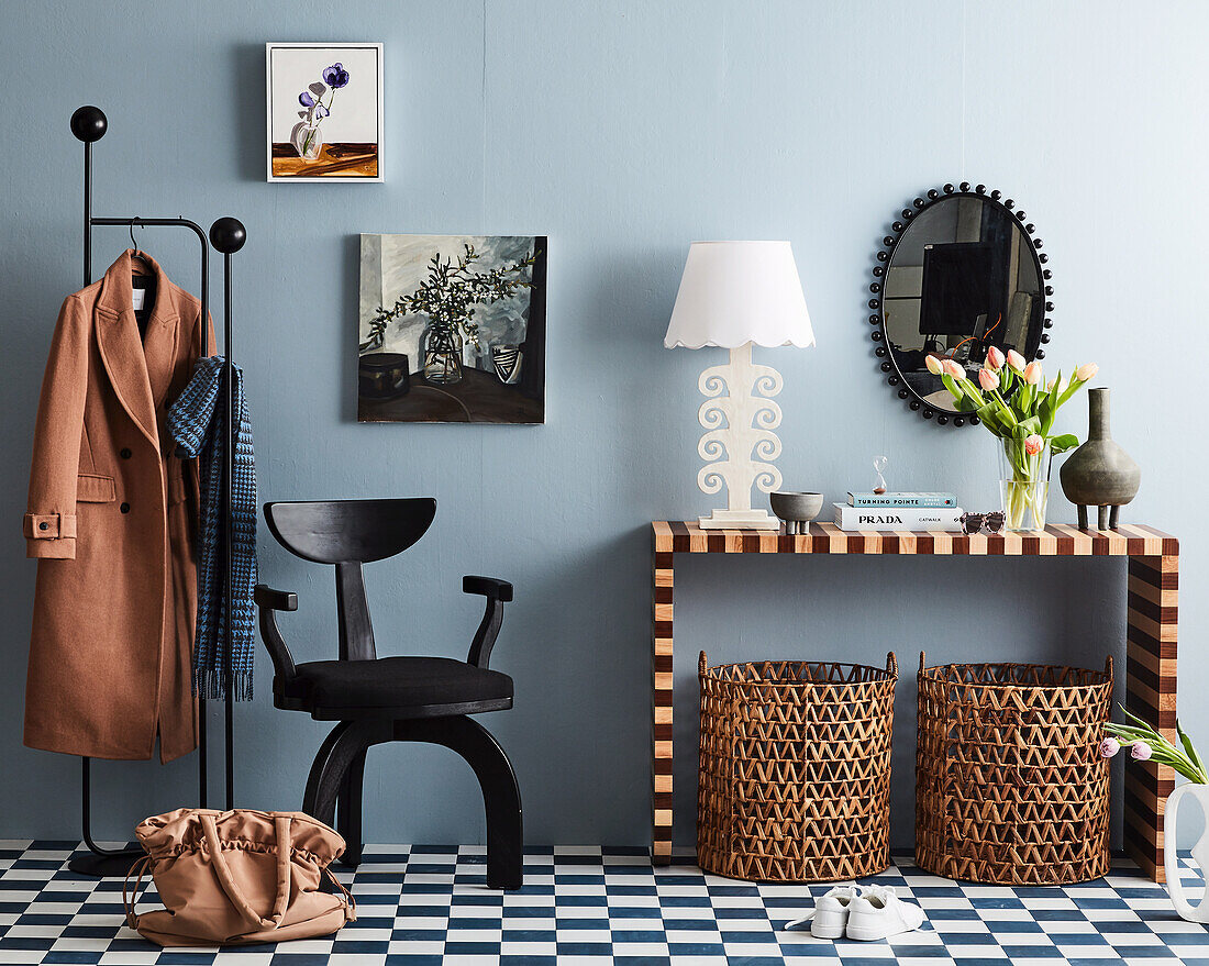 Konsolentisch, Designerstuhl und Garderobenständer in der Diele mit blauen Wänden