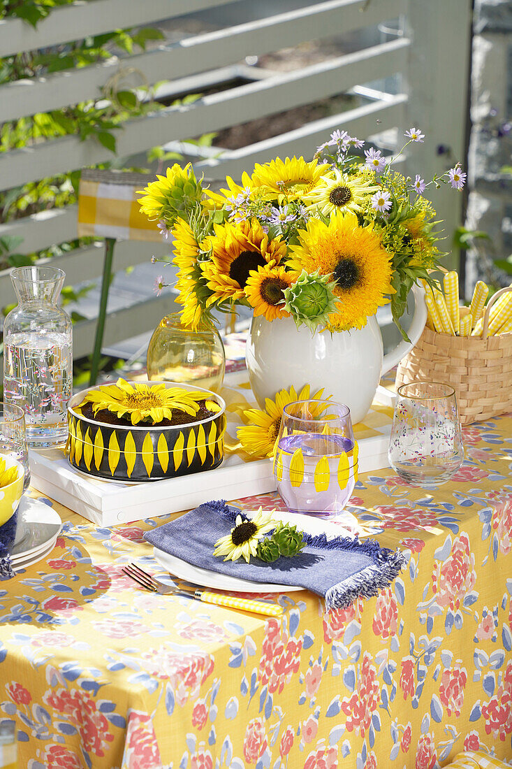 Gedeckter Tisch mit Sonnenblumenkuchen im Freien