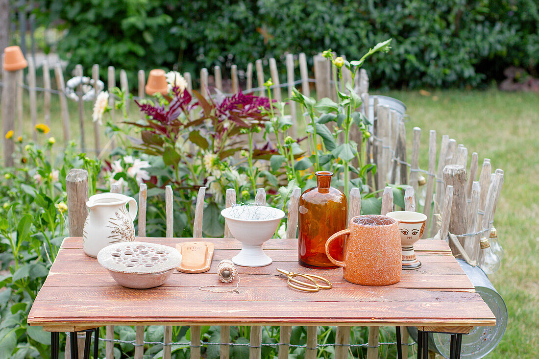 Different vessels for flower arrangement on a table in the garden