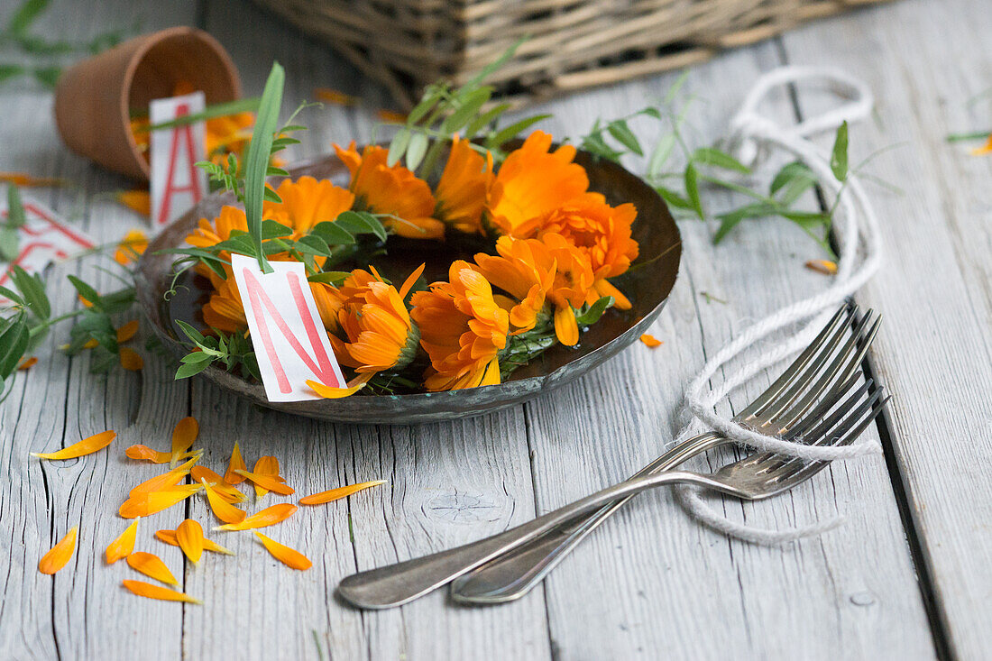 Wreath of marigolds (calendula), flowers on a plate with letters