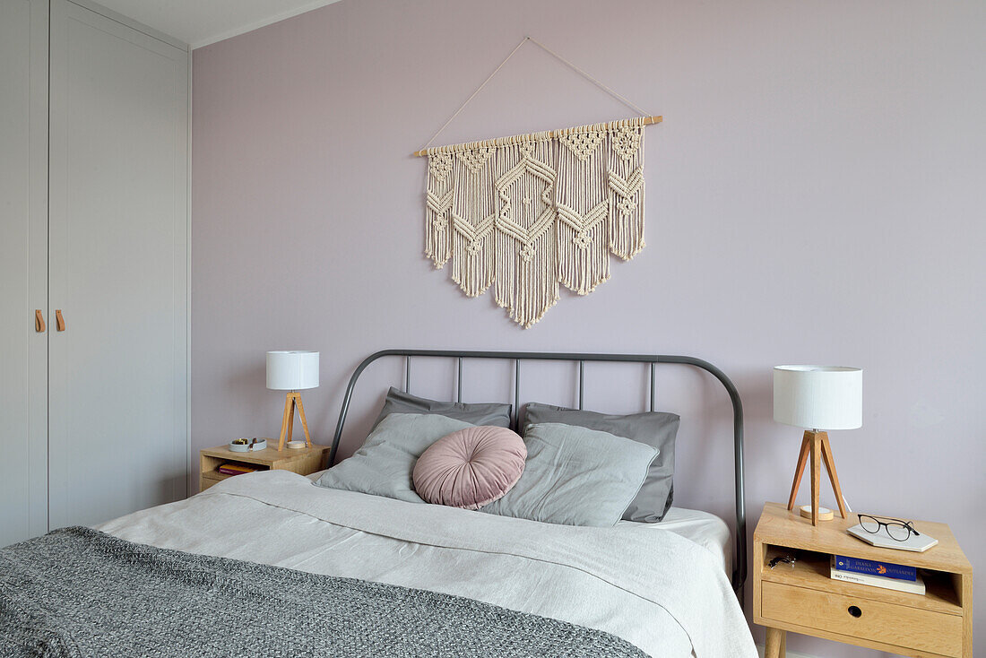 Simple double bed, macramé above and built-in closet in the bedroom