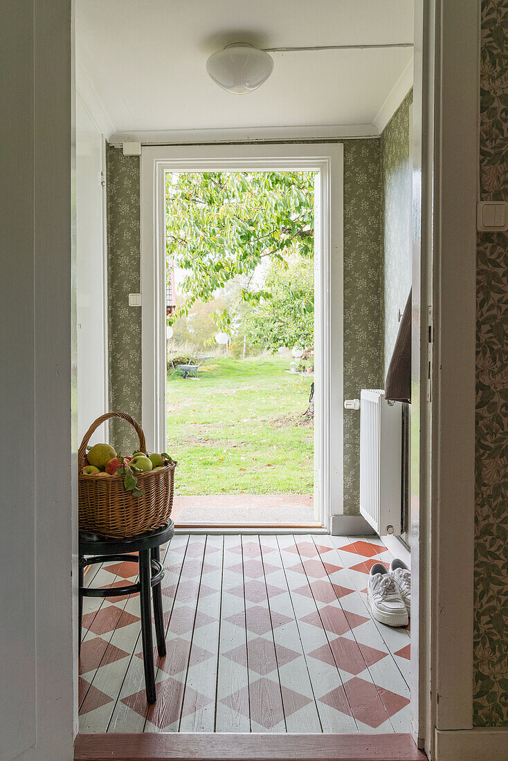 View into the hallway with checkered wooden floor and green wallpaper