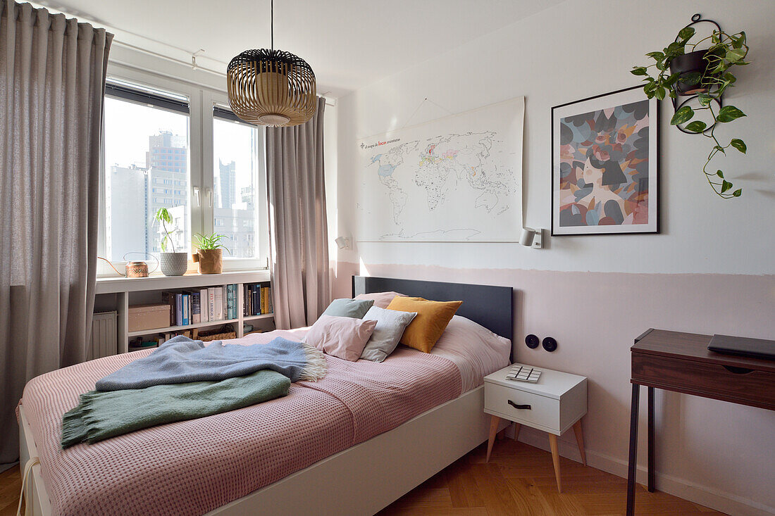 Doppelbett im Schlafzimmer mit pastellrosa Akzenten