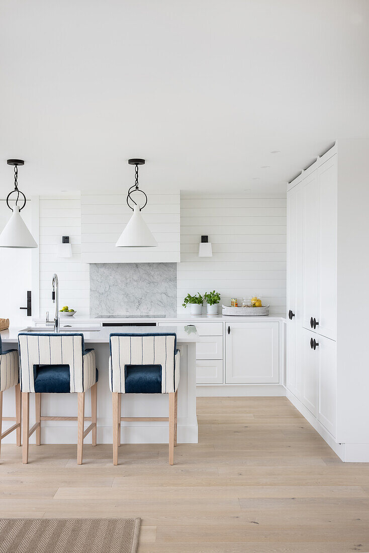 Bright kitchen, bar stools with blue and white upholstery at kitchen island