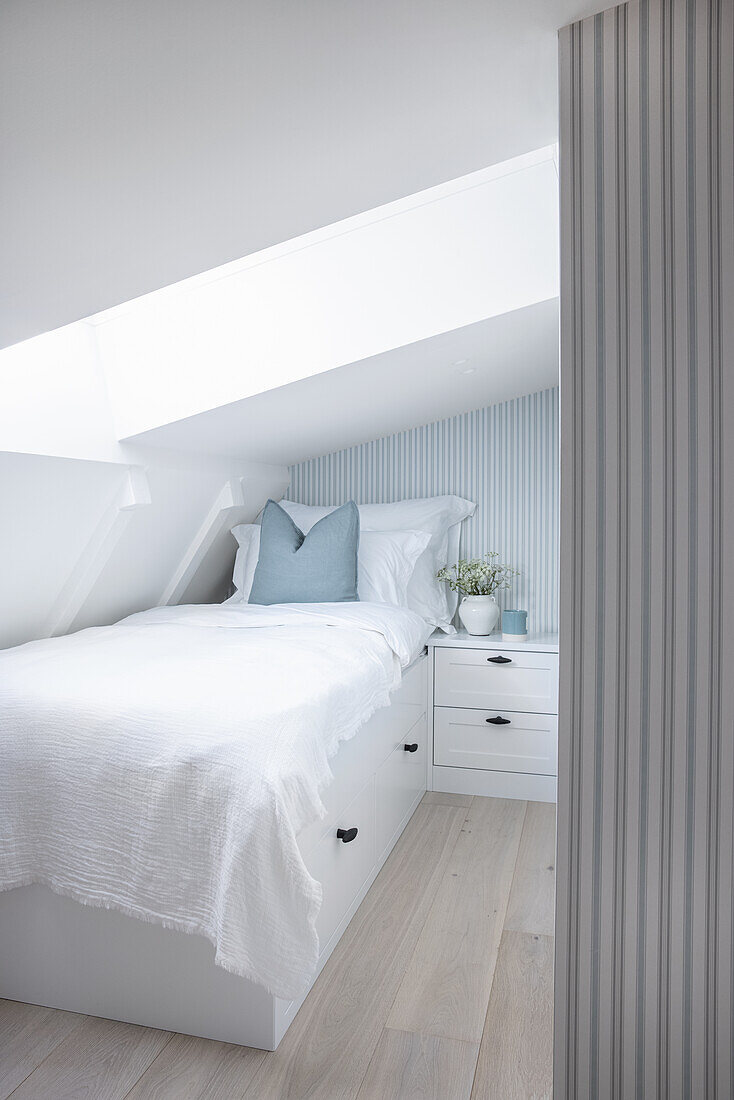 Single bed in light-colored attic room