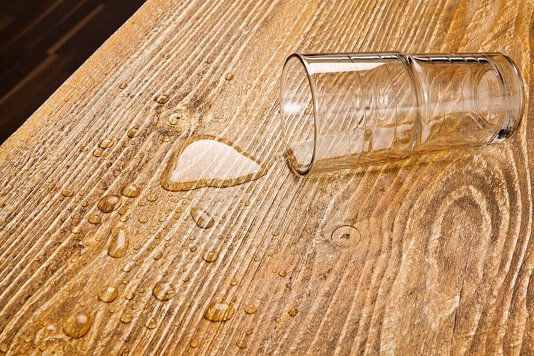 Umgekipptes Glas auf Holztisch