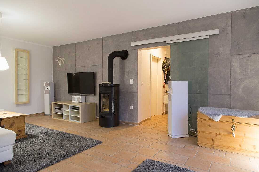 Modern living room with wood-burning stove and grey tiled walls