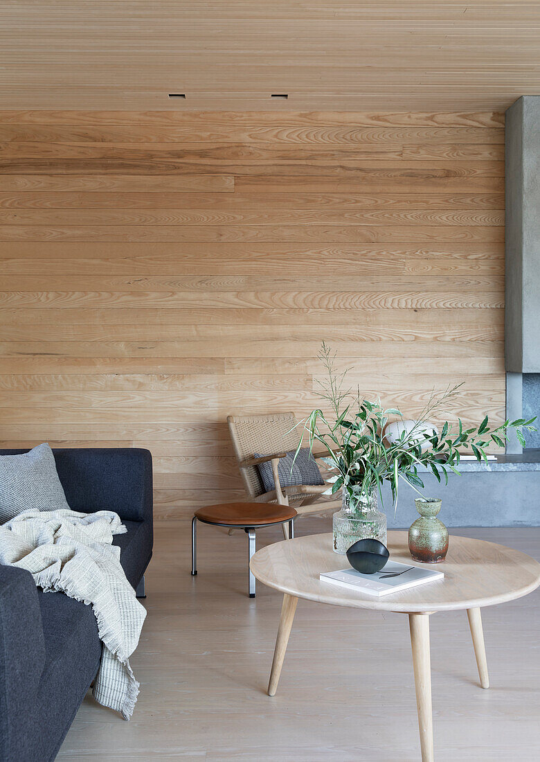 Sofa mit Coffeetable in hellem Raum mit Holzverkleidung
