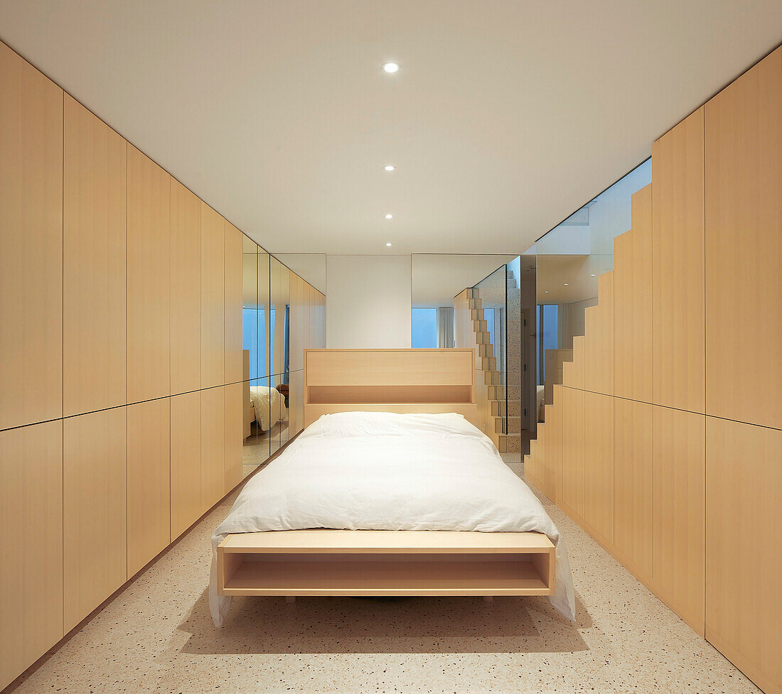 Minimalistisches Schlafzimmer mit Einbauten aus hellem Holz