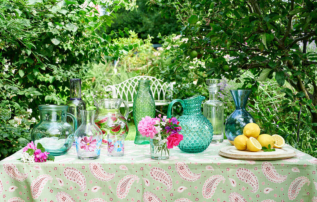 Collection of glass vases and jugs on a garden table
