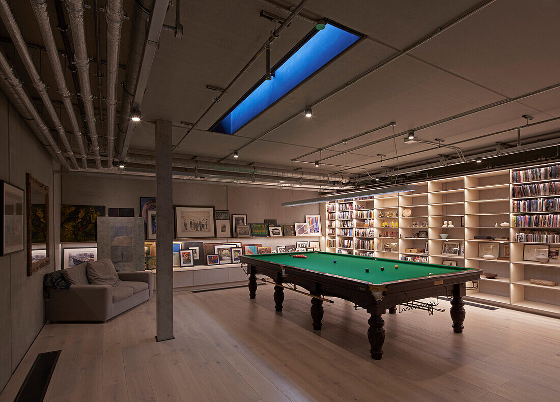 Basement with pool table, wall shelving unit, and an art collection