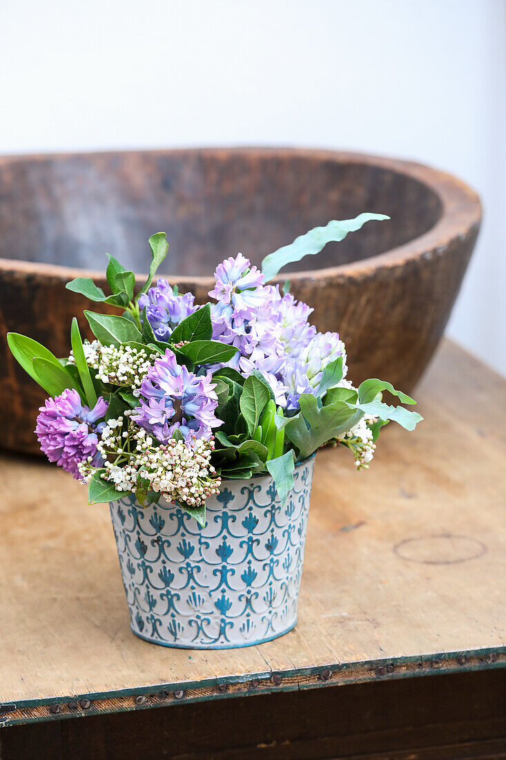Bouquet of hyacinths (Hyacinthus) and snowball (Viburnum) in vintage tin vase
